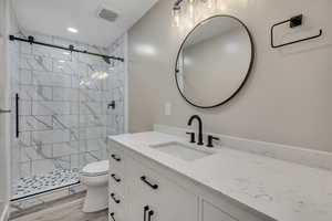 Full bath with vanity, a shower stall, light wood-style flooring, and recessed lighting