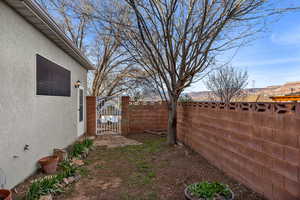 Fenced backyard with a gate and a mountain view