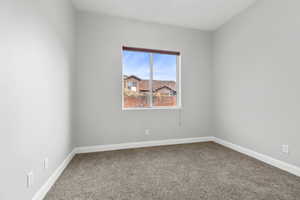 Carpeted empty room featuring baseboards
