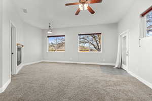 Empty room with light colored carpet and a ceiling fan