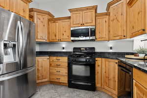 Kitchen featuring black appliances and dark stone countertops