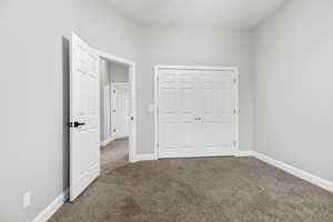 Unfurnished bedroom with carpet flooring and a closet