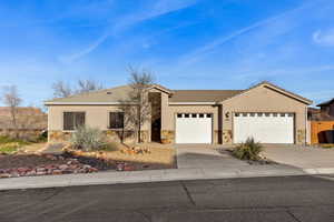 Ranch-style house with stone siding, an attached garage, driveway, and a tile roof