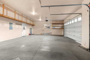 Garage featuring electric panel and baseboards
