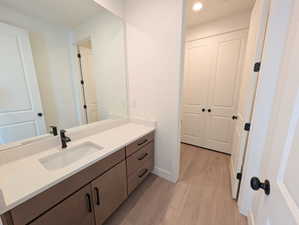 Main level Bathroom with vanity, light wood-style flooring, and recessed lighting