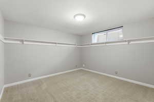 Spare room featuring light carpet and baseboards