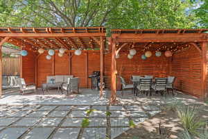 View of patio featuring outdoor lounge area, grilling area, and a pergola