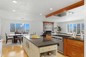 Kitchen featuring stainless steel appliances, pendant lighting, open shelves, and light wood-style flooring