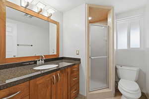 Full bath with a shower stall and vanity