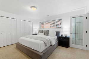 Bedroom featuring two closets and light colored carpet