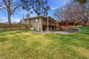 Back of house featuring a patio, a chimney, brick siding, a garage, and a balcony