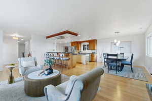 Living area with light wood-type flooring and a chandelier