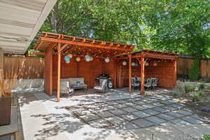 Fenced backyard with a pergola, an outdoor lounge area, a patio area, and area for grilling