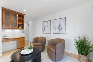 Living area with built in study area, recessed lighting, and light wood-style floors