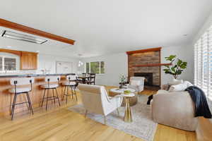 Living area with light wood-style floors, a fireplace, and recessed lighting