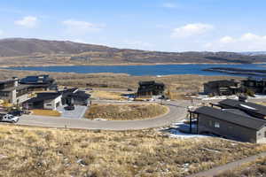 Water view featuring a mountain backdrop and nearby suburban area