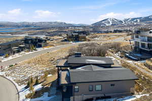 Snowy aerial view featuring a mountain view and a residential view