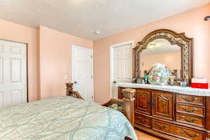 Bedroom with a textured ceiling and wood finished floors