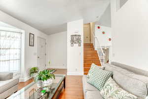 Living room featuring light wood-type flooring and a textured ceiling