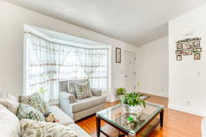 Living area with light wood-style floors and vaulted ceiling