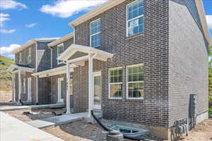 View of front of home featuring brick siding and a porch