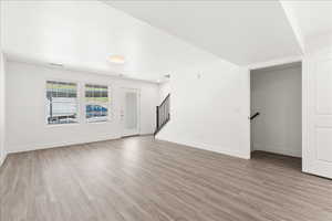 Unfurnished living room with baseboards and light wood-style flooring