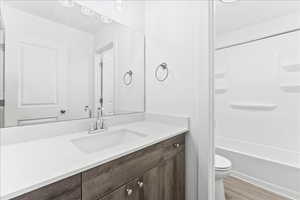 Bathroom featuring vanity, light wood-style floors, and shower / bathtub combination