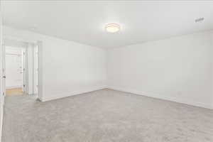 Empty room featuring light colored carpet