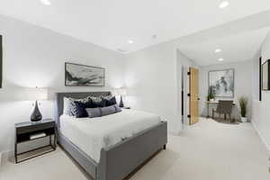 Bedroom featuring light carpet, recessed lighting, and a desk