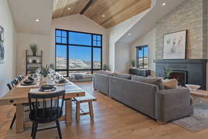 Living room featuring a mountain view, light wood-style flooring, a warm lit fireplace, and recessed lighting