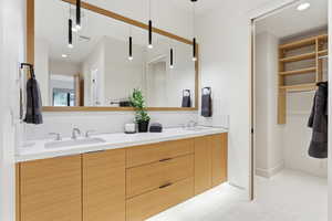 Full bathroom with recessed lighting, double vanity, and a spacious closet