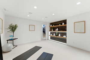 Exercise room with recessed lighting and light colored carpet