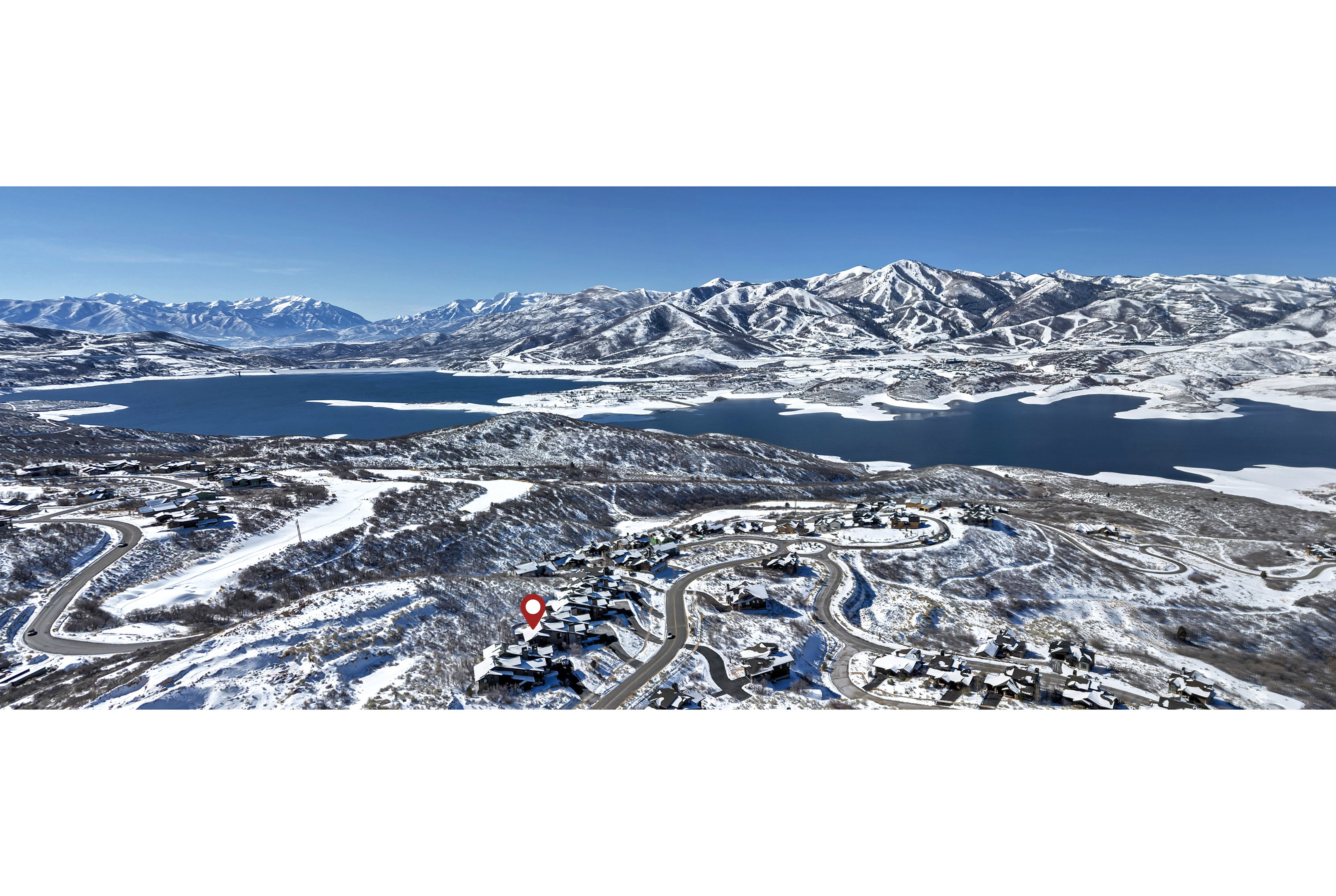 Snowy aerial view featuring a water and mountain view