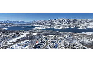 Snowy aerial view featuring a water and mountain view