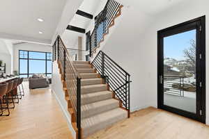 Foyer entrance with light wood-type flooring, a high ceiling, and recessed lighting