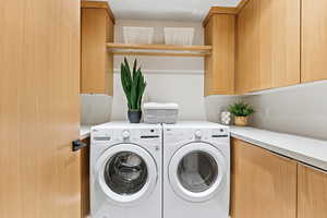 Laundry room featuring washer and dryer and cabinet space