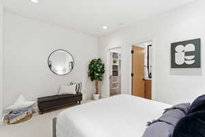 Carpeted bedroom with recessed lighting and ensuite bathroom