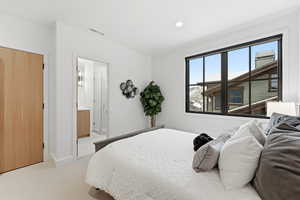 Bedroom with light carpet, connected bathroom, and recessed lighting