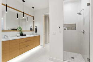 Bathroom with double vanity and a stall shower