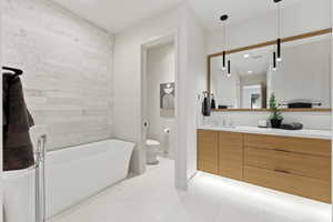 Bathroom featuring vanity, a freestanding tub, and light tile patterned floors
