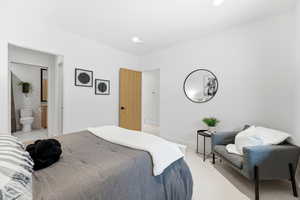 Carpeted bedroom featuring baseboards and ensuite bathroom