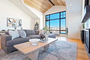 Living area with a high ceiling, light wood-style flooring, recessed lighting, and a mountain view