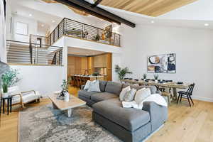 Living area with light wood-style flooring, recessed lighting, and lofted ceiling