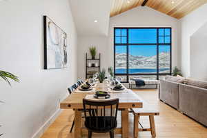 Dining area featuring light wood-type flooring, recessed lighting, a mountain view, and a high ceiling