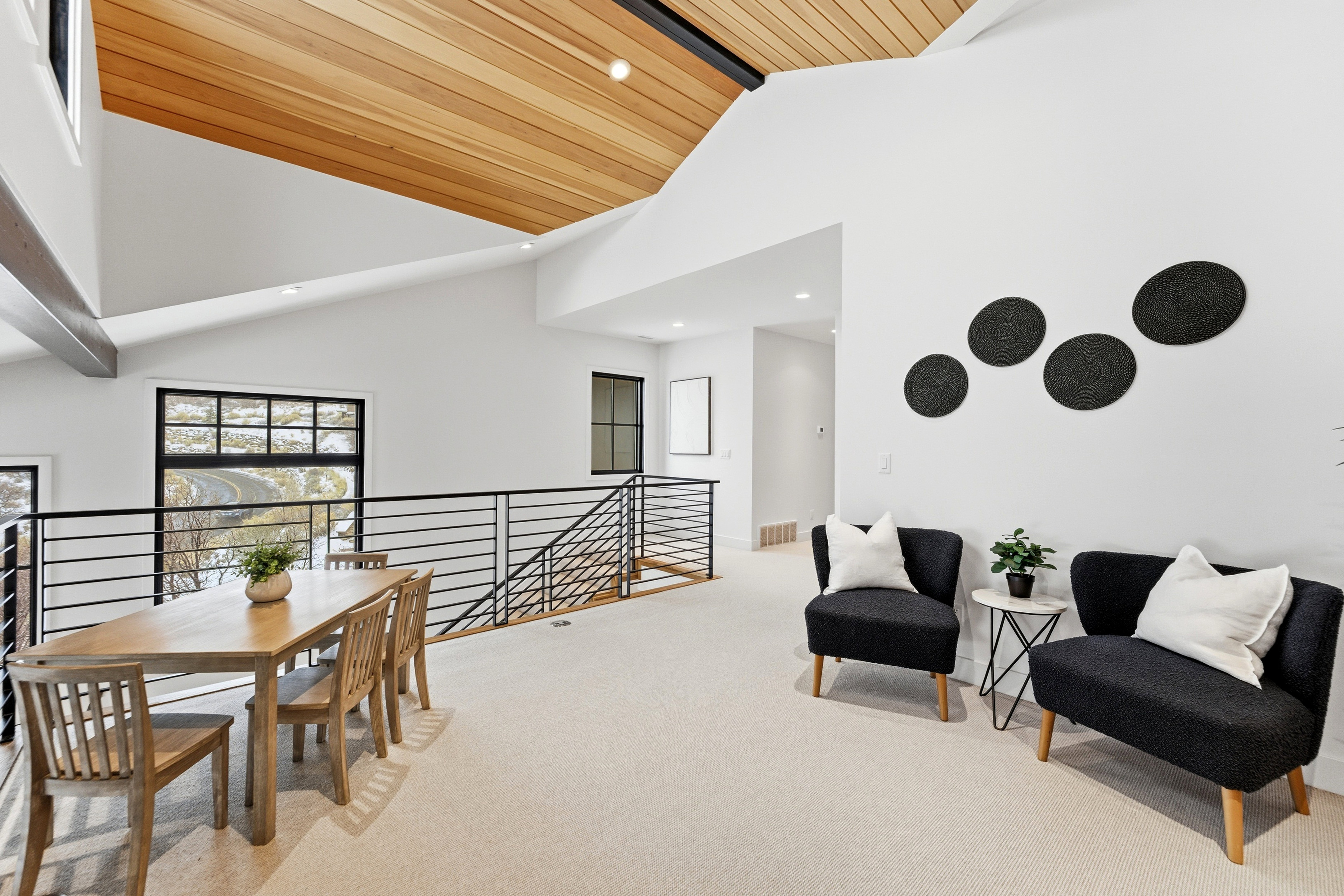 Living area with an upstairs landing, light colored carpet, recessed lighting, and a vaulted wood ceiling