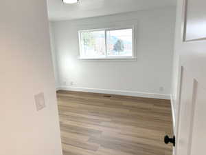 Empty room featuring wood finished floors and a textured ceiling
