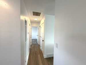 Hallway featuring dark wood finished floors and baseboards