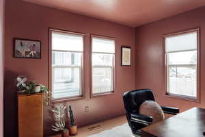 Home office with wood finished floors and healthy amount of natural light