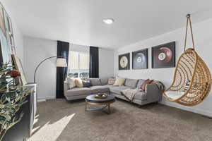 Carpeted living area featuring baseboards