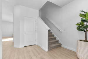 Stairs with wood finished floors and baseboards